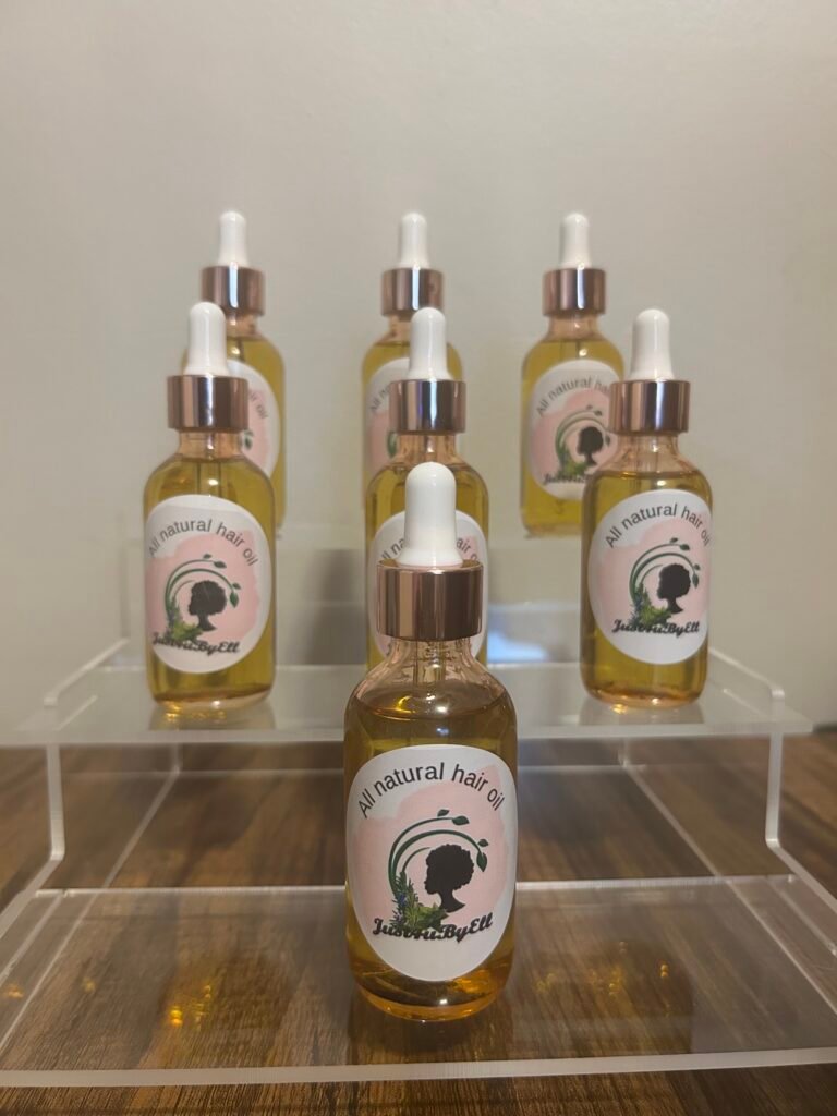 Bottles of Just4ubyEll all natural hair oil on a display stand
